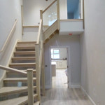 Light wooden banister with grey walls and with skirting