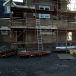 House getting rendered with ladder and scaffolding