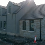 New home light grey walls with blue slate roof